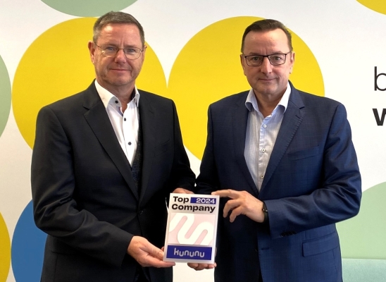ONTRAS Managing Directors Uwe Ringel and Ralph Bahke hold the Top Company Seal 2024 up to the camera with a smile.